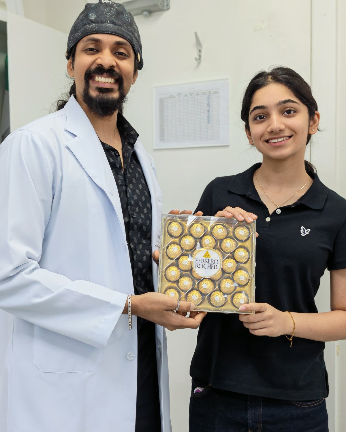 Dr. Keerthan with a young patient and a thank-you gift