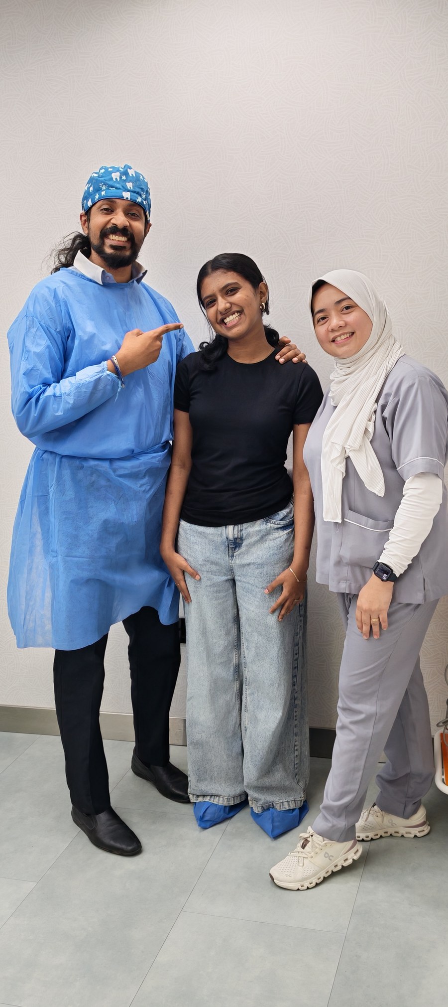 Dr. Keerthan with a patient and a staff member, all smiling